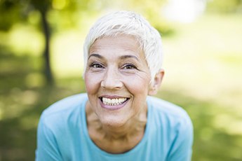 woman sitting outside and showing off her pearly whites 