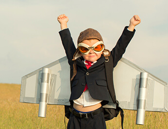 young child wearing red goggles and airplane