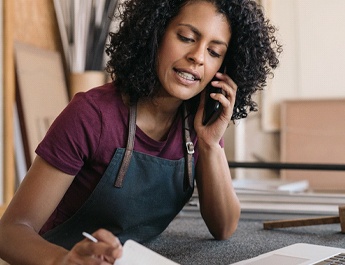 business owner speaking on cell phone to a customer