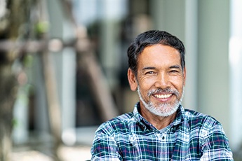 Older man with dental implants in Manchester smiling