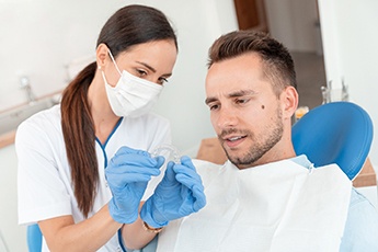 Female hygienist showing Invisalign in Manchester Center, VT to male patient