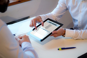 Dentist showing patient dental insurance form on tablet