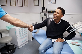 Young male patient shaking his dentist’s hand