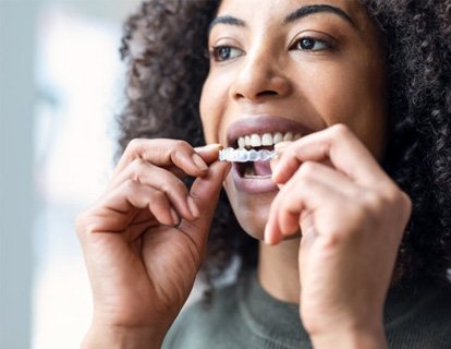 a woman preparing to wear her Invisalign aligners