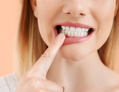 a woman pointing at signs of gum disease