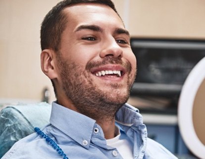 a patient checking his teeth with a mirror