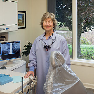 female dental hygienist standing by a monitor that displays an x-ray