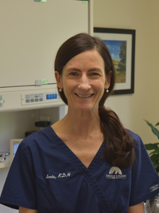 female with red long hair wearing dark blue scrubs