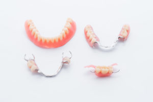 Collection of full and partial dentures on white background