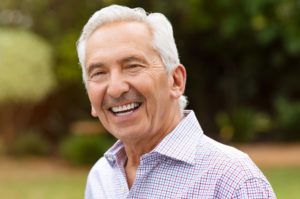 Older man with dental implants smiling