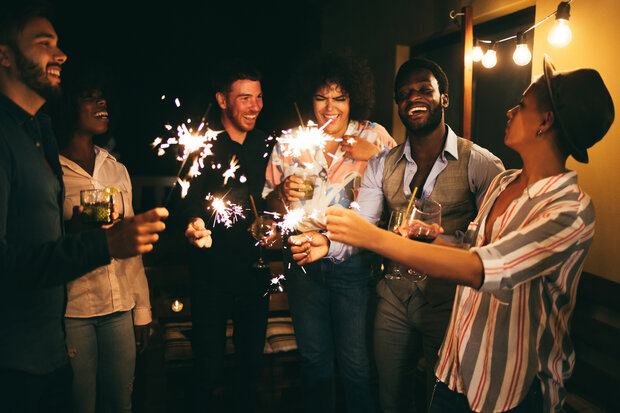 friends with healthy smiles in Manchester holding sparklers
