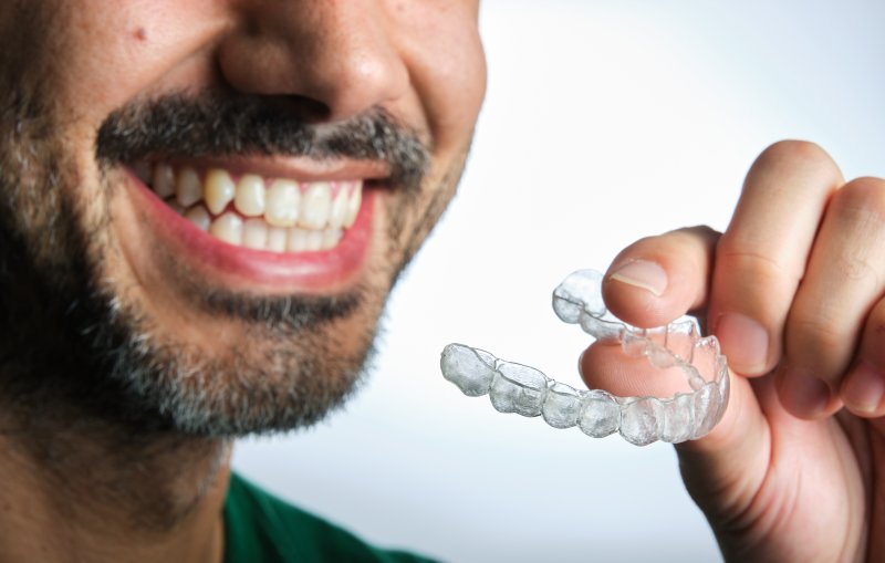Patient putting in their Invisalign refinements